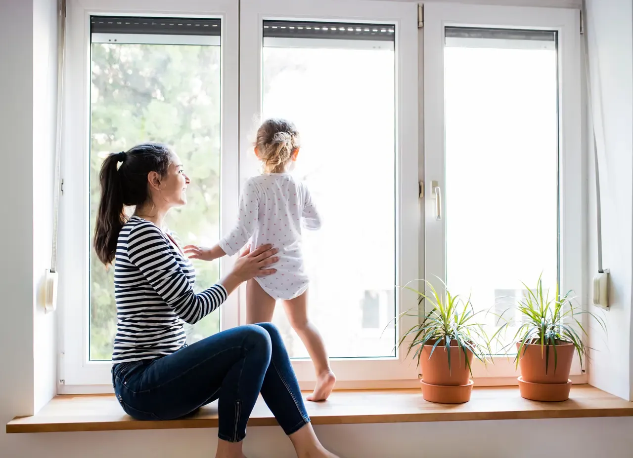 A parent and child stand in front of new Fiberglass Windows.